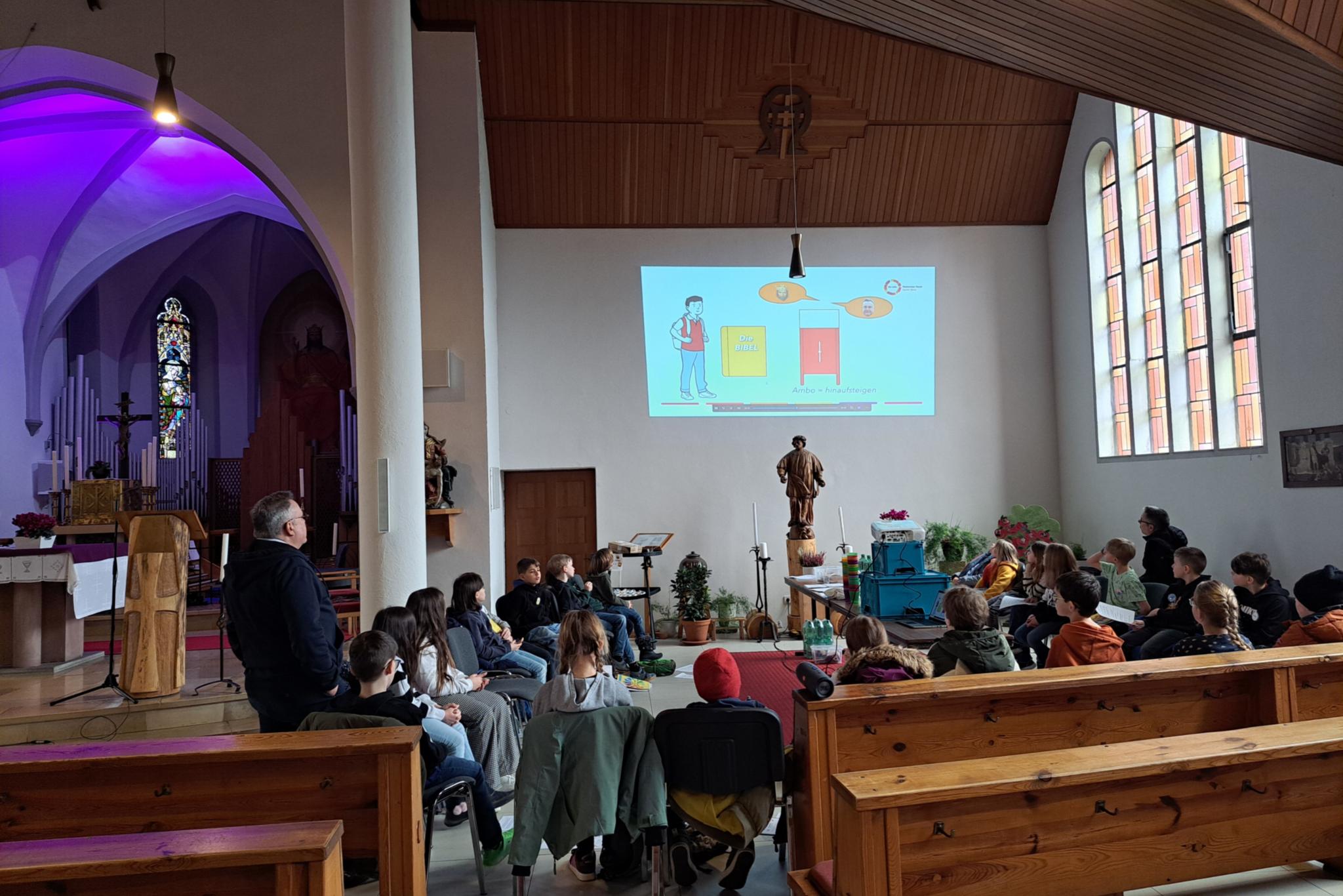 Die Kommunionkinder schauen das Erklärvideo 'Wir entdecken den Kirchenraum'